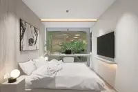 2 Bedroom Condo for Sale at Celine Wongamat modern bedroom with king bed, wood feature wall, wall-mounted TV, and tropical garden view