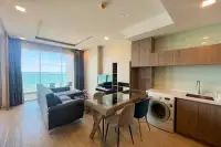 1 Bedroom Condo for Sale at Cetus Beachfront open-plan living and dining area with kitchen and ocean view balcony