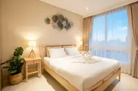1 Bedroom Condo for Sale at Veranda Residence Pattaya bright bedroom with wooden bed white linens towel swans and floor-to-ceiling window