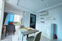 1 Bedroom Condo for Sale & Rent at Serenity Wongamat with dining area, living room, and bedroom doorway.