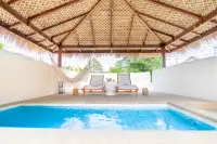 4 Bedroom House for Sale at The Sunshine House private pool with sun loungers and hammock under large thatched roof pavilion