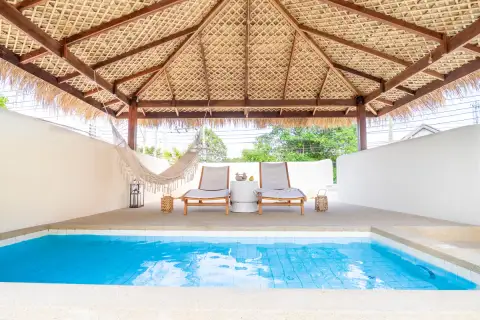 4 Bedroom House for Sale at The Sunshine House private pool with sun loungers and hammock under large thatched roof pavilion