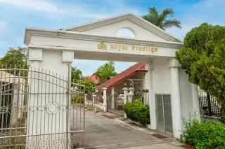 Royal Prestige grand white entrance gate with gold signage and ornate iron doors in Pattaya
