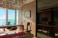 1 Bedroom Condo for Sale at Cetus Beachfront dining area with glass table, hanging wine glasses, wood-panel walls, and sea view