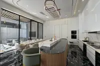 6 Bedroom House for Sale in Bang Lamung modern kitchen with marble island, dining table, and black marble floor.