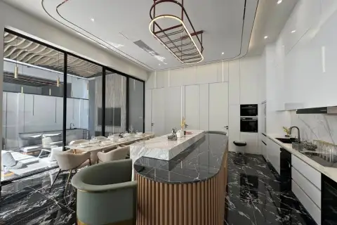 6 Bedroom House for Sale in Bang Lamung modern kitchen with marble island, dining table, and black marble floor.
