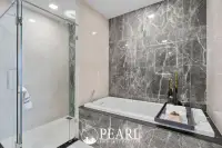2 Bedroom Grand Executive Condo for Sale at Aquarous Jomtien Pattaya: Bathroom with bathtub, glass shower, and marble accent wall.