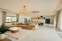 3 Bedroom House for Sale in Nong Prue spacious open-plan living room with L-shaped sofa marble floors and connected kitchen