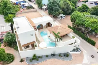 The Sunshine House bird's-eye view of private pool water slide thatched pavilion and tropical landscaped courtyard