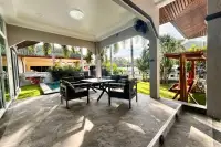 3 Bedroom House for Sale in Nong Prue covered outdoor patio with dark seating and a view of the garden and pool.