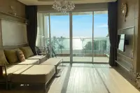 2 Bedroom Condo for Rent at Cetus Beachfront bright living room with sofa, chandelier, and floor-to-ceiling glass doors opening to sea view balcony
