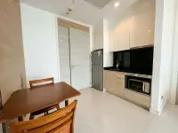 1 Bedroom Condo for Sale at Reflection Jomtien Beach kitchenette with fridge, microwave and dining table