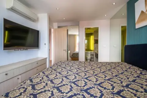 1 Bedroom Condo for Sale at Grande Caribbean bedroom with wall-mounted TV and ensuite bathroom view