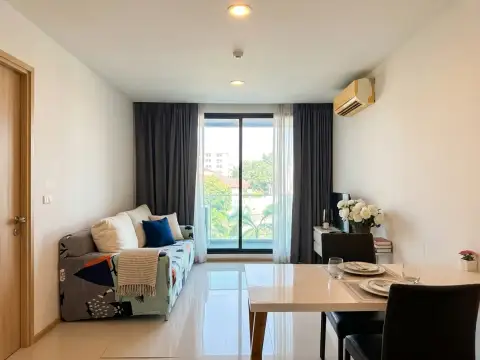 1 Bedroom Condo for Sale at Acqua Condo living and dining space with patterned sofa and balcony window
