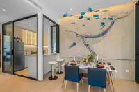2 Bedroom Condo for Sale at Once Wong Amat dining area with whale mural wall, blue chairs, and glass-partitioned kitchen
