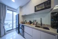 1 Bedroom Condo for Sale at Grand Solaire Noble: Kitchen with balcony access, showing the refrigerator and washing machine.