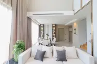 4 Bedroom House for Sale at Highbury Hill Pool Villas Pattaya open-plan living and dining area with high ceilings and wooden staircase