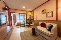 1 Bedroom Condo for Sale at D Condo Vite stylish bedroom with double bed, striped wallpaper, built-in wardrobe and city view window