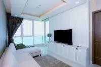 1 Bedroom Condo for Sale at Del Mare bright living room with white L-shaped sofa, flat-screen TV, and floor-to-ceiling sea-view windows