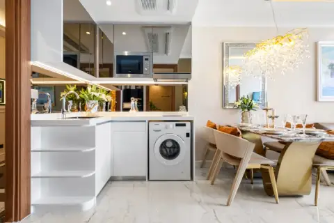 1 Bedroom Condo for Sale at The Riviera Malibu modern kitchen with white cabinets, microwave, and washing machine.