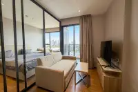 1 Bedroom Condo for Rent at Once Pattaya living area with sofa TV unit mirrored wardrobe and city view balcony