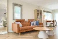 3 Bedroom House for Rent at Supalai Ville Pattaya - Motorway bright living room with tan leather sofa and herringbone wood floor