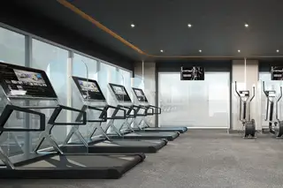 The Coral Pattaya, modern fitness center with treadmills, ellipticals, and large windows.