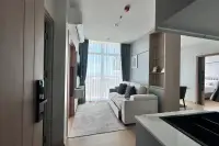 2 Bedroom Condo for Sale at The Twin Tower Jomtien Beach Pattaya open-plan living area with sofa, balcony view, and bedroom visible in background