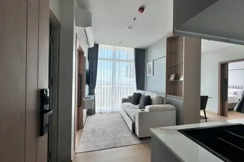 2 Bedroom Condo for Sale at The Twin Tower Jomtien Beach Pattaya open-plan living area with sofa, balcony view, and bedroom visible in background