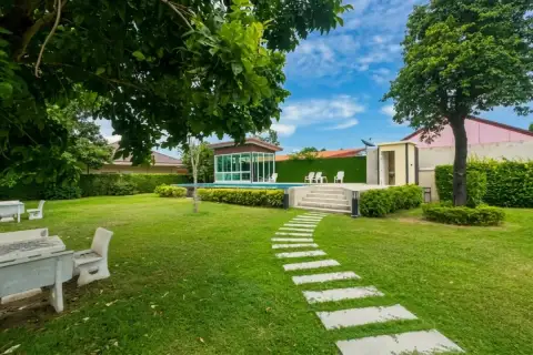 Garden Ville 5 entrance sign with gold lettering on marble wall and green hedges in Pattaya