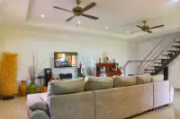 4 Bedroom House for Sale & Rent at Miami Villas living room with flat-screen TV, modern staircase and ceiling fans