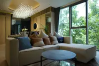 2 Bedroom Condo for Sale at SKYPARK Lucean Jomtien Pattaya spacious living room with crystal chandelier cream sectional sofa and floor-to-ceiling garden views