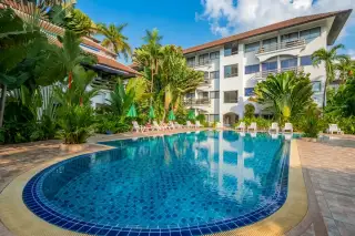 Diana Estate condominium building exterior with multiple balconies, a swimming pool, and tropical palm trees.