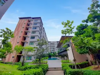 G Condo Sriracha courtyard view of apartment blocks and pool amid green landscaping