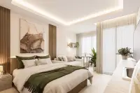 Studio Condo for Sale at Siam Oriental Beach: Bright studio interior with a bed, sofa, and sheer curtains by the window.