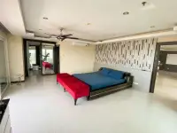2 Bedroom Condo for Sale at PKCP Tower spacious bedroom with blue bed, red bench, and ceiling fan