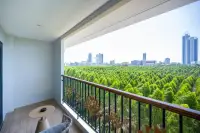 2 Bedroom Condo for Sale at Wyndham Jomtien Pattaya - living space with dining table and balcony overlooking city.