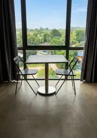 1 Bedroom Condo for Sale at Sea Zen dining nook with two chairs overlooking lush green landscape