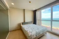 1 Bedroom Condo for Sale at Cetus Beachfront bright bedroom with double bed and floor-to-ceiling window with direct sea view