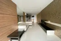 3 Bedroom Condo for Sale at Apus open living area with wood-panel wall, white tile floors, and decorative string curtain divider