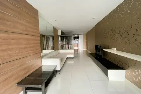 3 Bedroom Condo for Sale at Apus open living area with wood-panel wall, white tile floors, and decorative string curtain divider