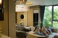 2 Bedroom Condo for Sale at SKYPARK Lucean Jomtien Pattaya open-plan living and dining area with crystal chandelier wood slat walls and lush garden views