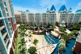 Grande Caribbean pirate ship water park feature with a slide, water jets, pool, and surrounding residential buildings.