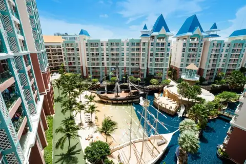 Grande Caribbean pirate ship water park feature with a slide, water jets, pool, and surrounding residential buildings.