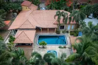 5 Bedroom House for Sale in Huai Yai from an aerial view, showcasing the house, two pools, and surrounding greenery.