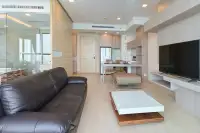 1 Bedroom Condo for Sale at Cetus Beachfront open-plan living area with leather sofa, kitchen, dining table, and glass-enclosed bathroom