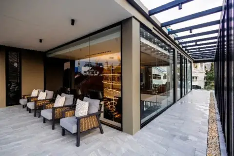 5 Bedroom House for Rent at Casa Jomtien: Outdoor covered terrace with lounge chairs and glass walls.