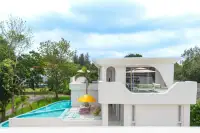 6 Bedroom House for Sale in Huai Yai side view of pool terrace with yellow umbrella sun loungers and upper balcony seating