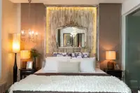 1 Bedroom Condo for Sale at Cetus Beachfront bedroom with backlit feature wall, ornate mirror, candle chandelier and warm ambient lighting