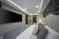 2 Bedroom Condo for Sale at Grand Solaire Noble master bedroom with wall-mounted TV and tufted headboard against black marble wall